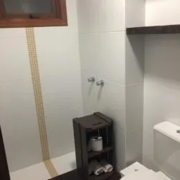 Foto de uma parede revestida com azulejos brancos em um ambiente interno.