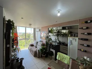 Sala de estar com vista para a paisagem externa e cozinha integrada.