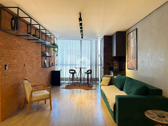 Sala de estar com piso de madeira e parede de tijolos aparentes.