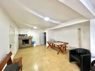 Sala de estar com piso de cerâmica e lareira em ambiente claro.