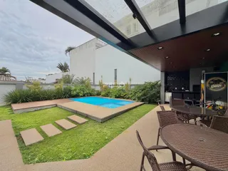 Vista externa de uma área de piscina e jardim em uma propriedade no Brasil.