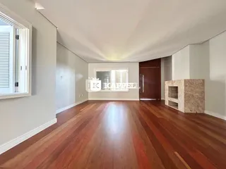 Foto de um corredor com piso de madeira polida e paredes brancas.