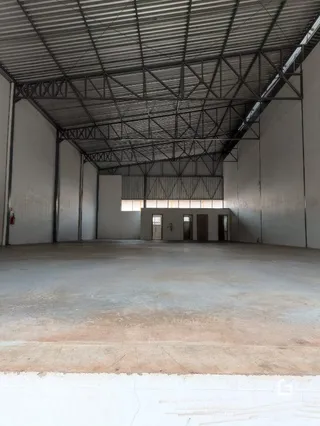 Imagem de um espaço interno grande e vazio com teto de estrutura metálica.