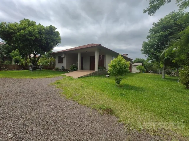 Vista externa de uma residência com gramado e paisagismo.