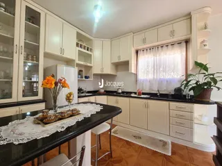 Foto de uma sala de estar com armários brancos e piso de madeira clara.