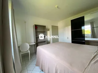 Quarto com cama e armário em um ambiente claro e bem iluminado.