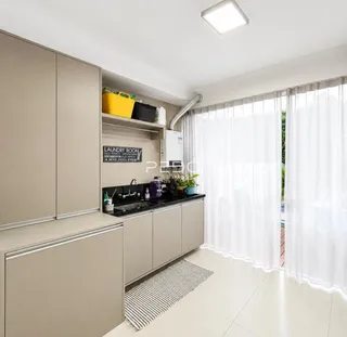 Vista interna de uma cozinha com armários e janela em um imóvel.