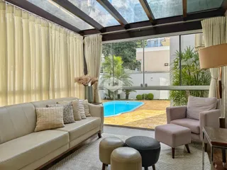 Sala de estar com vista para a piscina e jardim externo.