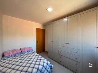 Quarto com armários embutidos e cama de casal.