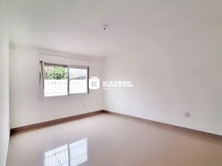 Uma sala ampla e vazia com janela voltada para o exterior.