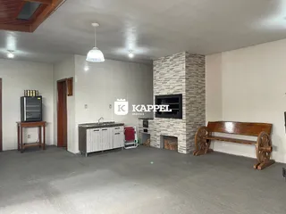 Sala de estar com lareira de pedra e móveis de madeira.