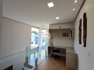 Ambiente moderno com piso de madeira e acesso a uma varanda.