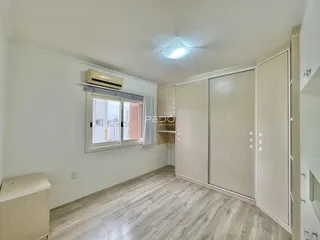 Foto de um interior com piso de madeira clara e armários embutidos