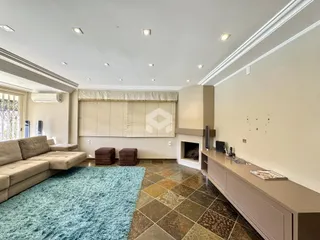 Sala de estar com piso de cerâmica e lareira em um imóvel no Brasil.