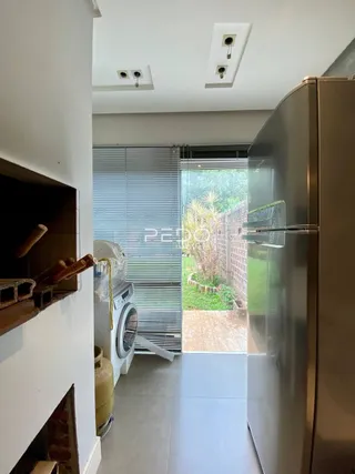 Vista de uma cozinha moderna com porta de vidro abrindo para o jardim.