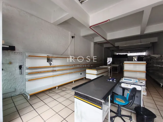 Foto de um ambiente interno com prateleiras brancas e piso cerâmico.