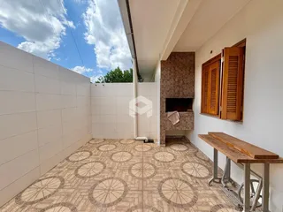 Vista de uma área interna com piso de cerâmica e parede branca em uma residência.