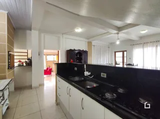 Foto de uma cozinha com armários escuros e bancadas pretas.