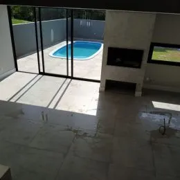 Vista de uma piscina externa através de portas de vidro.