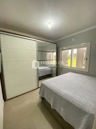 Quarto com cama e portas de correr brancas.