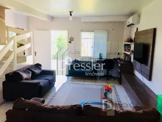 Sala de estar com escadaria e sofá no interior da propriedade.
