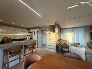 Sala de estar e cozinha moderna com iluminação clara.