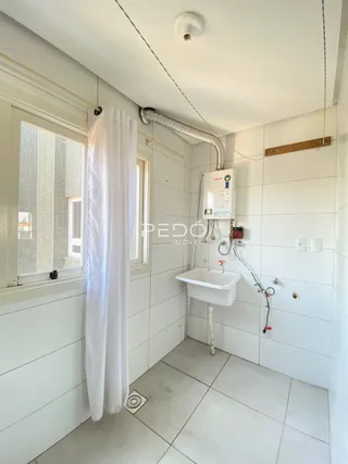 Foto de um banheiro com paredes brancas e piso de cerâmica.