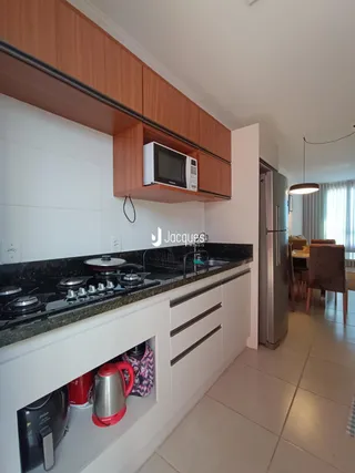 Foto de uma cozinha moderna com armários de madeira e bancada escura.
