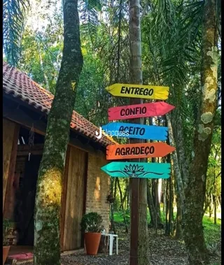 A fachada de uma casa de madeira cercada por árvores.