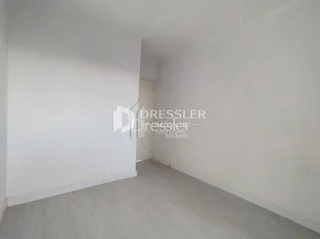 Interior de um ambiente com paredes brancas e piso claro.