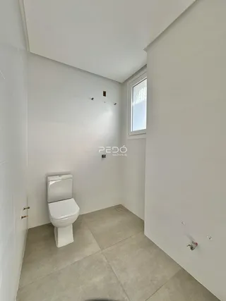 Foto de um banheiro com paredes brancas e piso cinza claro.