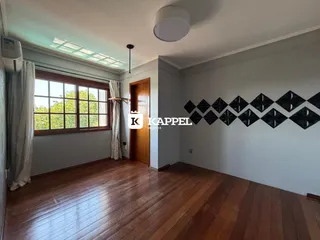 Sala de estar com piso de madeira e grande janela.
