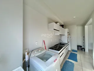 Interior da cozinha com armários brancos e máquina de lavar roupa.