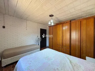 Quarto com paredes de tijolo branco e armários de madeira.