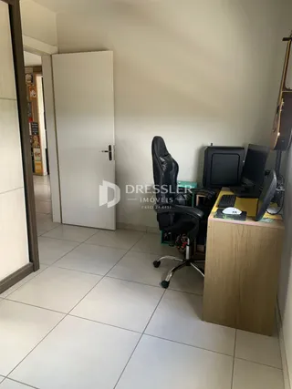 A foto mostra um corredor interno com uma porta branca.