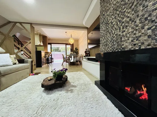 Sala de estar moderna com piso de madeira e lareira em um ambiente amplo.