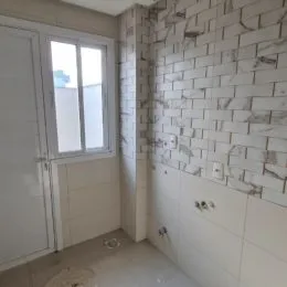 Parede interna com revestimento de azulejos brancos em um ambiente.
