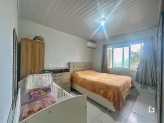 Quarto com cama e guarda-roupa em ambiente interno.