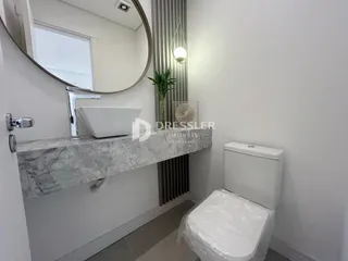 Banheiro com bancada de mármore e vaso sanitário branco.