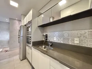 Cozinha moderna com armários brancos e revestimento decorativo.