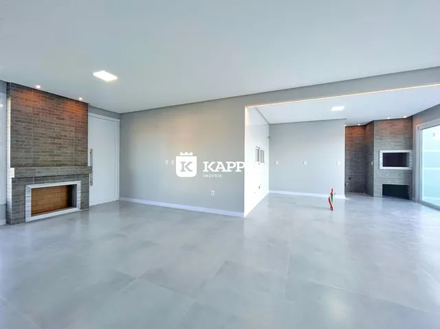Ambiente amplo com piso claro e lareira de tijolos aparentes em uma sala de estar.