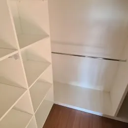 Foto de um interior com prateleiras brancas e piso de madeira.