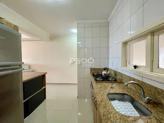 Foto da cozinha com bancada de granito e piso claro.