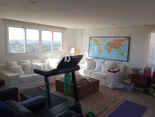 Sala de estar iluminada com vista para a paisagem através das janelas.