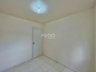 Ambiente interno com paredes brancas e piso de cerâmica.