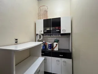 Interior de um corredor com armários brancos e pretos.