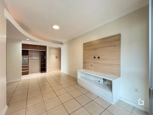 Ambiente interno com piso de cerâmica e painel de madeira na sala.