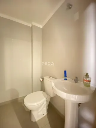 Foto de um banheiro com vaso sanitário e pia brancos.