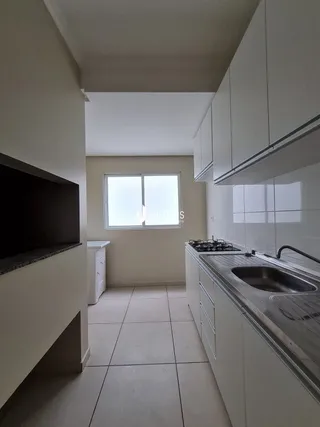 Vista interna de um corredor com paredes brancas e piso claro.