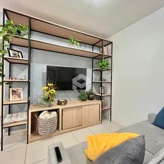 Sala de estar com estante e televisão em ambiente moderno.